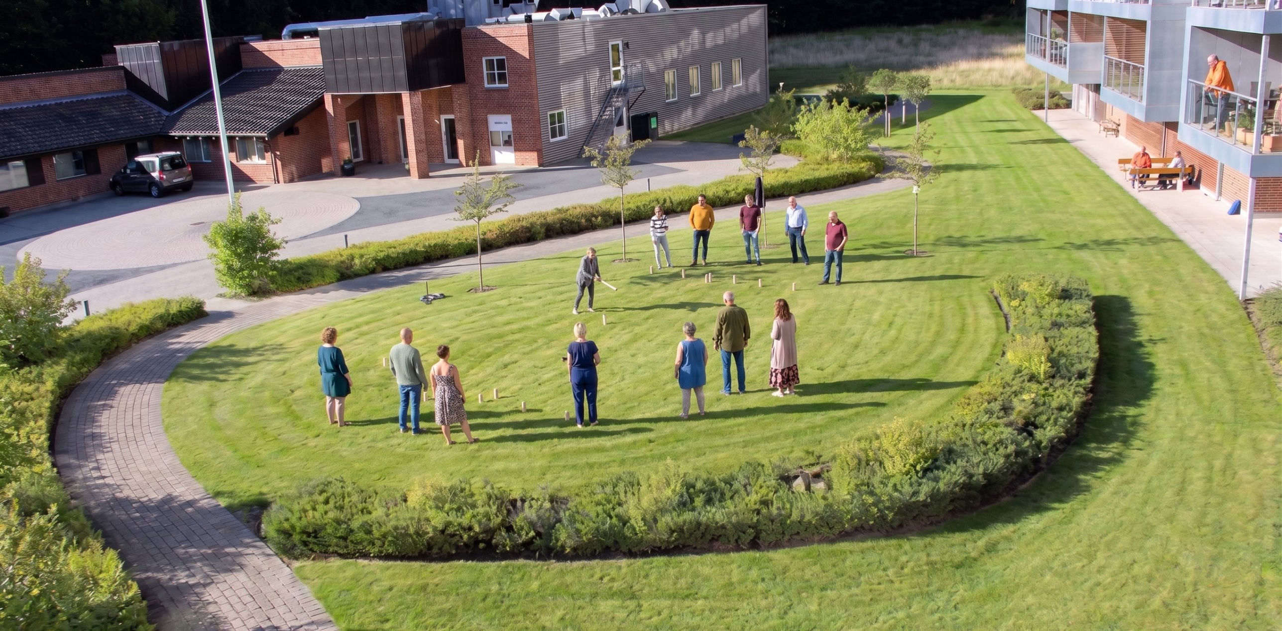 Beboere fra Den Grønne Smaragd spiller kubb på fællesarealet en sommeraften